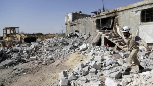 A civil defence member walks on the rubble of a damaged building next to a site hit by what activists said were airstrikes carried out by the Russian airforce. Photo credit: CBS News