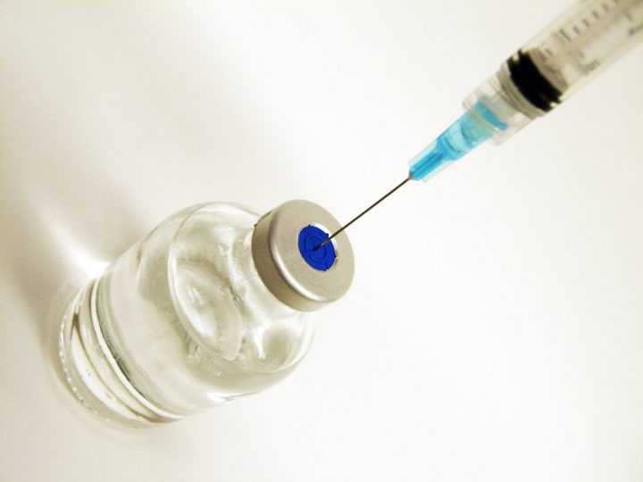 A needle entering a vial.